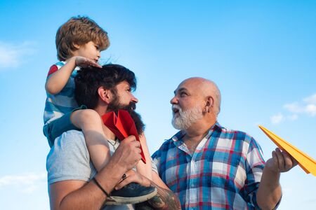 Family people. Airplane ready to fly. Male multi generation family. Kid pilot with toy jetpack...