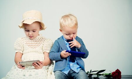 social net in phone. small kid with red rose. formal little boy and girl. friendship relations....