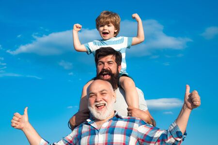 Fathers day concept. Happy three generations of men have fun and smiling on blue sky background. Happy family.の写真素材
