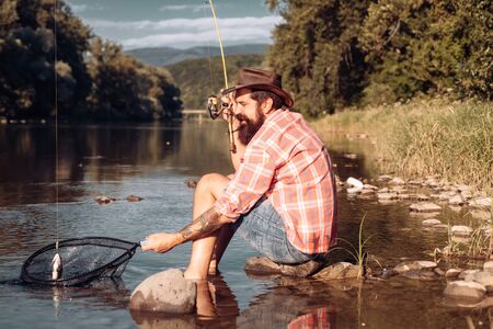 Fly fishing for trout. Men fishing in river during summer day. Man fly fishing.の写真素材