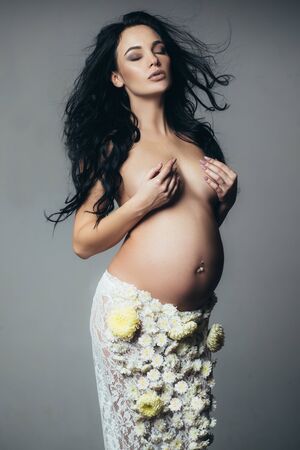 life birth expectation. Love. beautiful pregnant woman in spring flower skirt. future mother has baby inside. womens health. girl with big belly. pregnancy. Maternity preparation. expectation conceptの写真素材