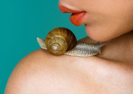Cosmetics and snail mucus. Cosmetology beauty procedure. Girl and cute snail. Skin care. Massage with snail. Skincare repairing. Healing mucus. Having fun with adorable snail. Spa and wellnessの写真素材