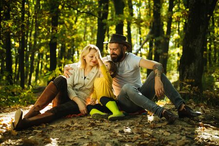 Family day concept. Happy family with kid boy relaxing while hiking in forest. Mother father and small son picnic. Picnic in nature. Country style family. Meaning of happy family. United with natureの写真素材