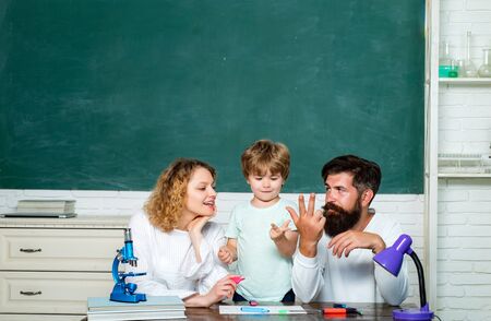 Child from elementary school with parents in school. Elementary student. Nice family photo of little boy and his Parents. Kids at preschool.の写真素材
