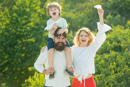 Happy joyful family having fun throws up in the air little boy child. Happy family with kid on summer field - dream of flying concept. Happy family on holiday.の写真素材