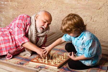 Kid Playing Chess. Chess piece. Grandfather and grandson concept.の写真素材