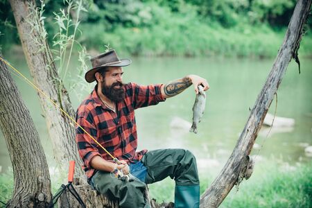 Fishing became a popular recreational activity. Fish head and fishing hook. Brown trout fish....