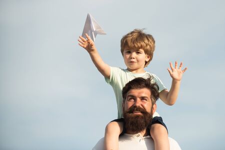 Fathers day. Happy family - father and son on meadow with a toy paper airplane in the summer on the nature background.の写真素材