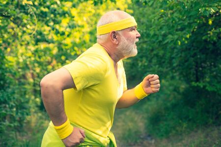 Senior runner in nature. Cardio workout. Running in park in the morning. Senior male is enjoying sporty lifestyle. Healthy lifestyle conceptの写真素材