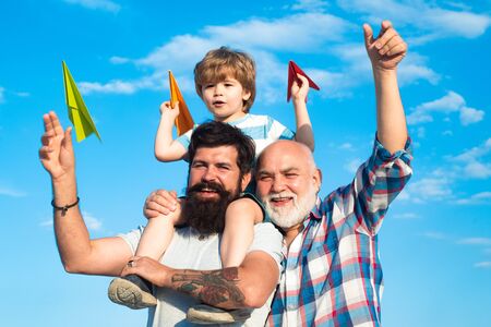 Men generation: grandfather father and grandson are hugging looking at camera and smiling. Three...