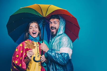 People in rain. The autumn mood and the weather are warm and sunny and rain is possible. Rain and umbrella november concept. Happy family in Autumn.の写真素材