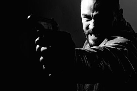 Killer or murderer concept. Mafia killer going to shot someone. Finish him. Kill them all. Final shot. Concentrate on gun shot. Need for revenge. Close up gun barrelの写真素材