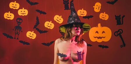 Female with sexy ass posing on pumpkin. Halloween sexy concept. Night Party background. Nude woman witch with halloween hat and pumpkin. Lingerie for Halloween.の写真素材