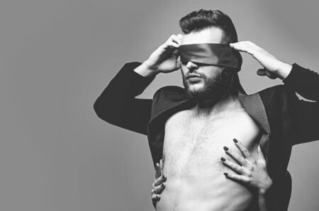 Blindfolded. Sexy girl closes eyes of a man. Woman covering man eyes.の写真素材