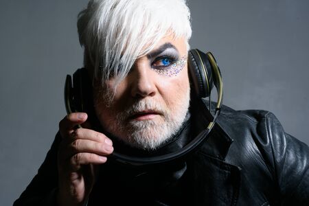 Let music flow in your heart. Hipster man with fashion hairstyle. Bearded man with male makeup wear...