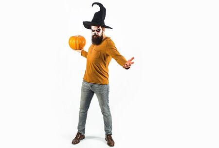 Portrait of man with Halloween skull make up showing his emotions - full length. Halloween design with copy space. Scary face man with horror Make up holding Pumpkin head jack lantern.の写真素材