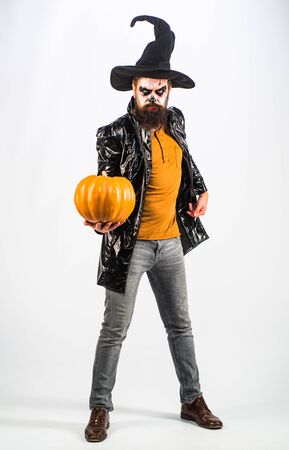 Young man with witch hat dressed as vampire for Halloween party - full length. Bearded man dressed like Halloween monster. White background isolated. Halloween bearded man with blood make-up.の写真素材