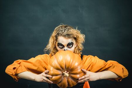 Halloween art design. Beautiful young surprised woman in witch hat costume and holding Witch broom. Happy Halloween witch with pumpkin. Witch eyes.の写真素材