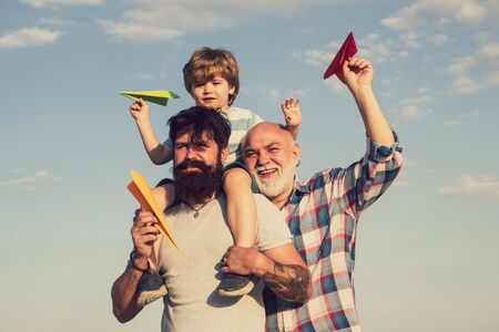 Men in different ages. Happy child playing outdoors. Father son and grandfather playing - family time together. Child happy. Father and son playing outdoors.の写真素材