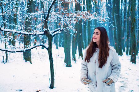 Winter portrait of young pretty beautiful woman in cold sunny winter weather in park. Season of Winter. Outdoors.の写真素材