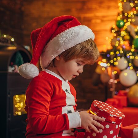 Family holiday. Santa boy celebrate christmas at home. Boy child play christmas decorations. Merry and bright christmas. Childhood activity and game. Christmas attributes. Childhood memoriesの写真素材