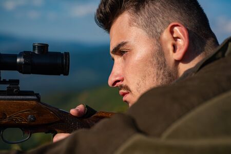 Close-up Target with optic sight. Snipers carbine at the outdoor hunting - close up portrait. Hunter with his rifle. Process of duck hunting.の写真素材