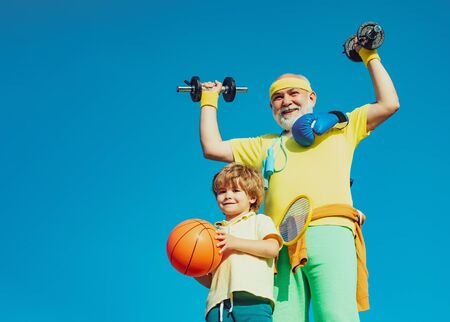 Family sport. Like sports. Fathers day. Healthy family lifestyle. Grandfather and child is doing sport outdoors. Healthy and active lifestyle at any age concept.の写真素材