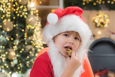 Christmas child. Merry Christmas. Thanksgiving day and Christmas. Milk and gingerbread cookie for Santa against Christmas light background.の写真素材