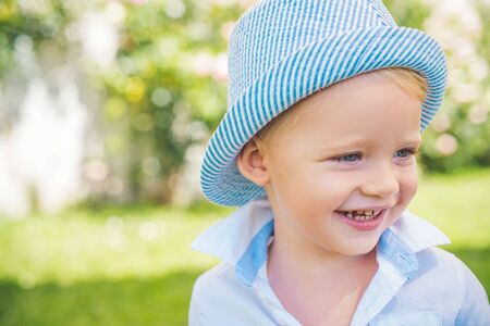 Child face. Portrait of happy smiling child boy on nature background. Child play outdoors. Funny little boy.の写真素材