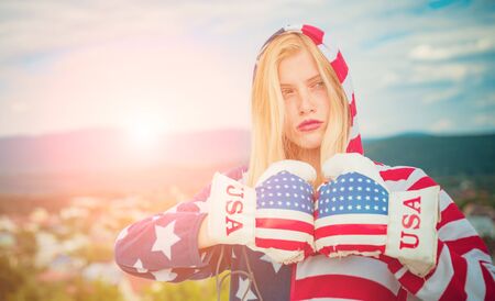 Woman american boxer with boxing glove. Young happy woman with flag of united states enjoying. 4th of July Independence day. Beautiful cheering happy young girl joyful excited.の写真素材