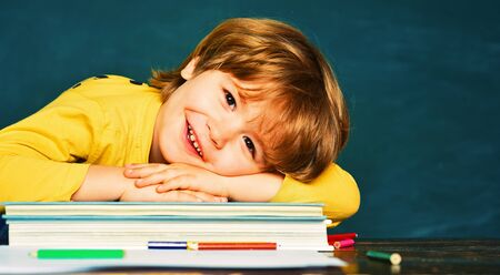 Back to school and happy time. Kid is learning in class on background of blackboard. Cheerful smiling child at the blackboardの写真素材