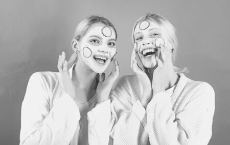 Girls friends, sisters or mom and daughter chilling making clay facial mask. Anti age mask. Stay beautiful. Skin care for all ages. Women having fun cucumber skin mask. Natural clay facial maskの写真素材