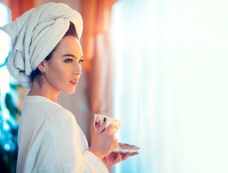 Good morning. Sensual woman. Beautiful Girl with morning coffee at home. Perfect clean skin. Women Health. Beauty woman in bedroom and enjoying the morning. High Resolution.の写真素材