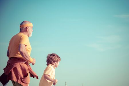 Jog and run marathon for family. Running in park in the morning. Grandpa and grandson is enjoying sporty lifestyle. Healthy lifestyle concept. Healthy old young lifestyleの写真素材