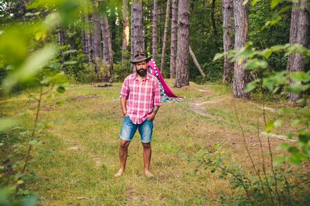 Natural background. Bearded man relax in forest. Mature hipster with beard. Guy in forest. Summer camping. Serious bearded man.の写真素材