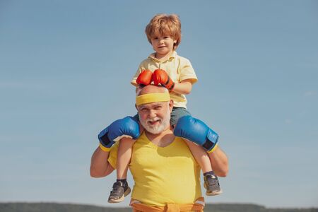 Grandfather and child fighting poses. Grandpa and little child boy in boxing stance doing exercises...