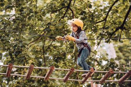 Toddler climbing in a rope playground structure. Children fun. Child concept. Safe Climbing extreme...