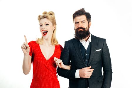 Funny retro couple. Family photo of emotional young couple isolated at white background. Blonde woman shows gesture that she has an interesting idea. Young couple in love forever.の写真素材