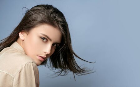 Sensual model girl with smooth skin and makeup. Cheerful happy young beautiful girl. Female fasion. Portrait of serious desire woman. Portrait of a beautiful woman in a white blouse. Grey background.の写真素材
