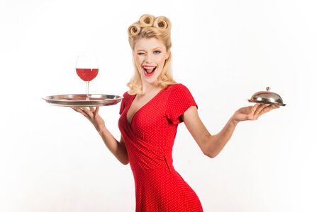 Smiling fashionable pinup girl. Perfect makeup and hairstyle. Beauty trends. Beautiful blonde woman in red dress.の写真素材