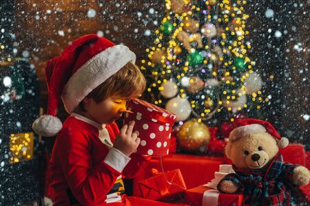 It is miracle. Boy cute child cheerful mood play near christmas tree. Merry and bright christmas. Santa boy little child celebrate christmas at home. Lovely baby enjoy christmas. Family holidayの写真素材