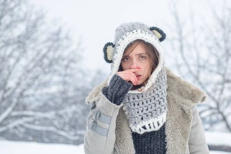Sick in winter. Cold flu winter season, runny nose. Showing sick woman sneezing at winter park....