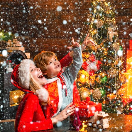 Mother and little child boy adorable friendly family having fun. Family having fun at home christmas tree. Mom and kid play together christmas eve. Happy family. Family holiday. Santa claus coming. Family in snow.の写真素材