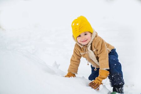Happy child boy playing on a winter walk in nature. Happy kid having fun on winter field with snow. Winter Christmas emotion.の写真素材