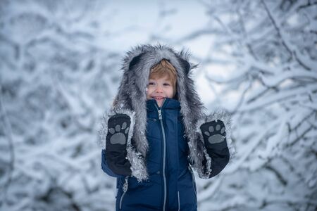 Joyful child Having Fun in Winter Park. Cute child in Winter park trees covered with snow. Well...