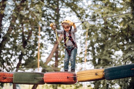 Early childhood development. Children fun. Go Ape Adventure. Children summer activities. Toddler age. Child concept. Adventure climbing high wire park.の写真素材