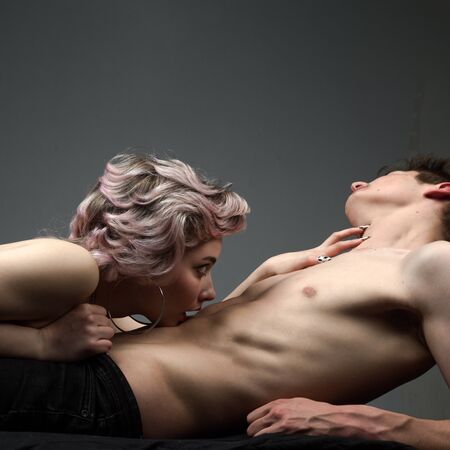 Attractive man and woman being playful. Tender picture of young couple. Trust. Full portrait of happy couple isolated on grey background. Prelude couple in love. Relationship. Love and trust.の写真素材