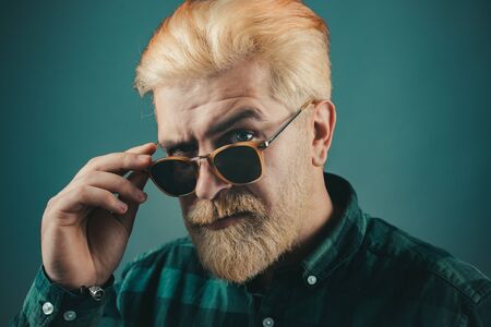 Bearded man with fashion sunglasses. Close up portrait of a very handsome man. Beautiful guy in...