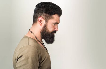 Perfect long beard. Close-up of young bearded man standing against gray backgroundの写真素材