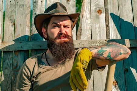 Portrait of father while working in garden. Farmer on farmland. Planting concept. Farmer harvesting fresh vegetables from the garden and planning harvest.の写真素材